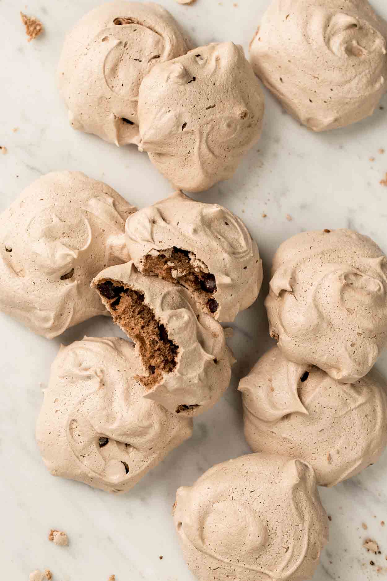 Chocolate chip meringue cookies on a platter stacked on top of each other.