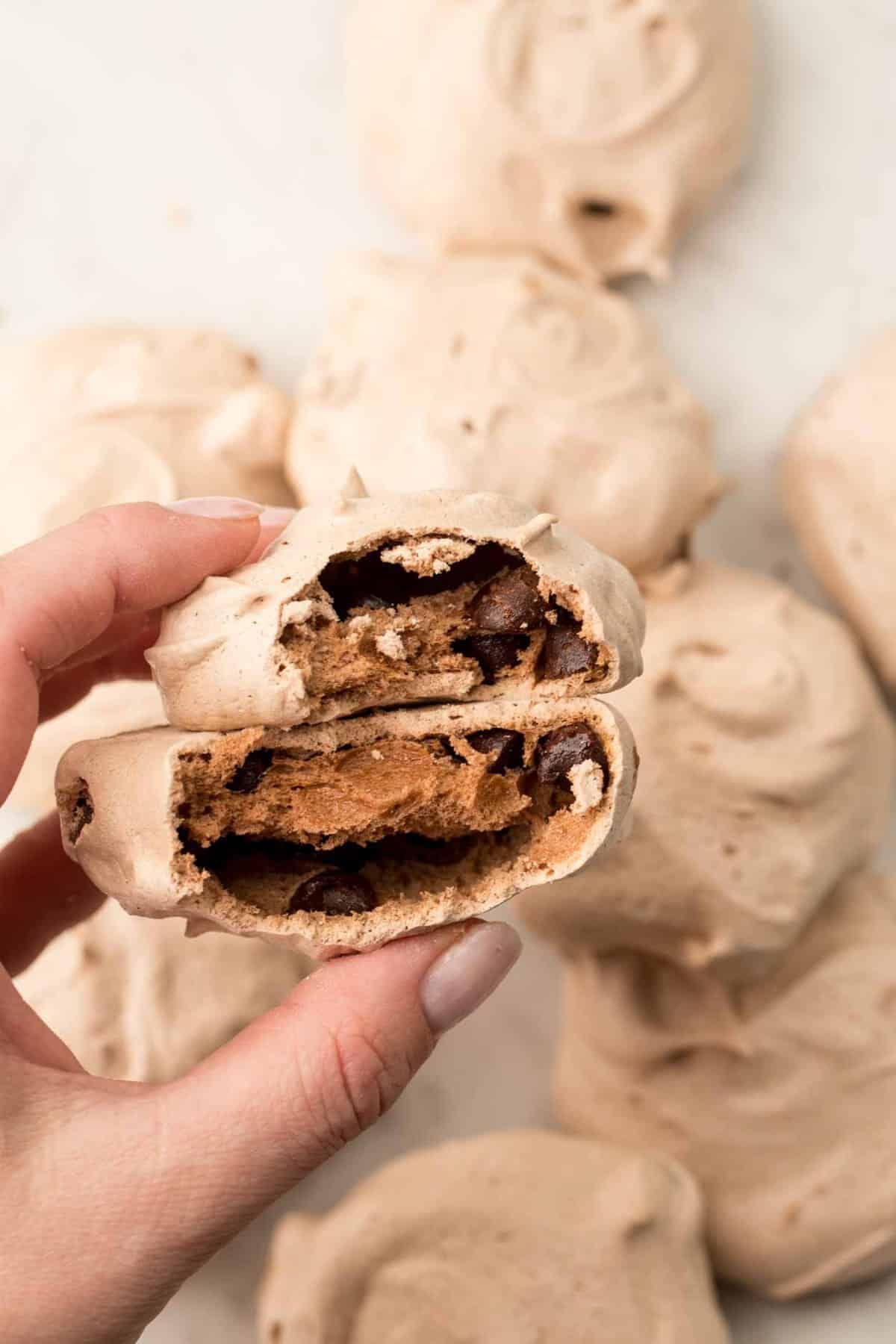 Bit into chocolate meringue cookies to show thick chocolate center.