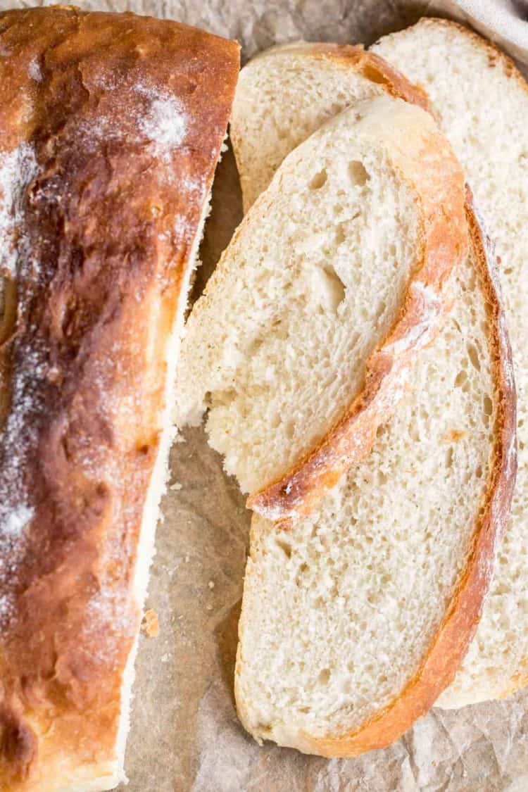 Sliced white italian bread loaf on a cutting board.