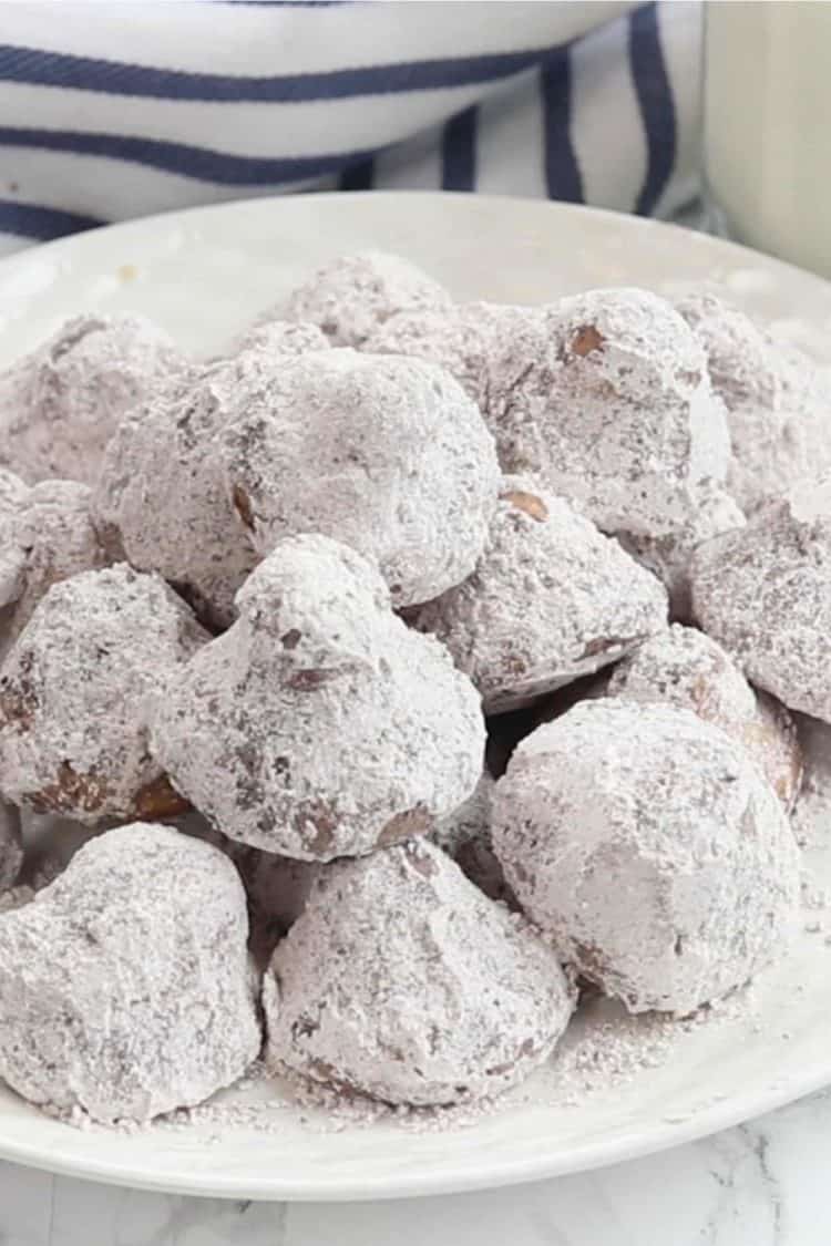 Truffle cookie kisses on a plate topped with powdered sugar. 