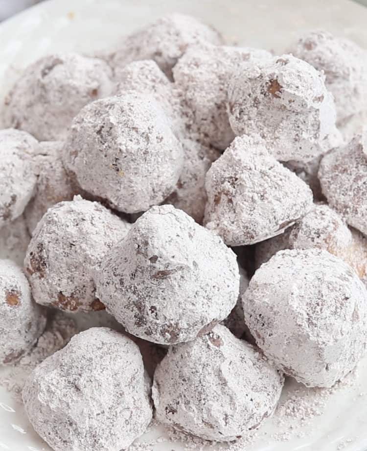 Close up picture on truffle cookies coating in cocoa powder and powdered sugar.