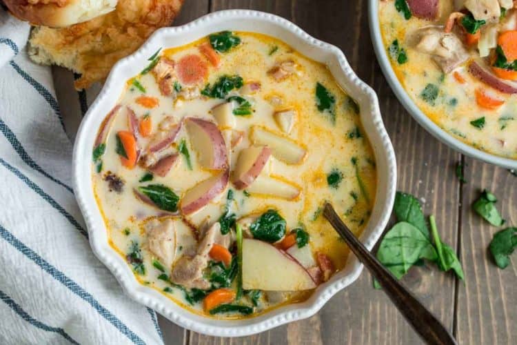 Easy potato soup recipe made with potatoes, chicken, spinach and carrots in a bowl with a spoon.