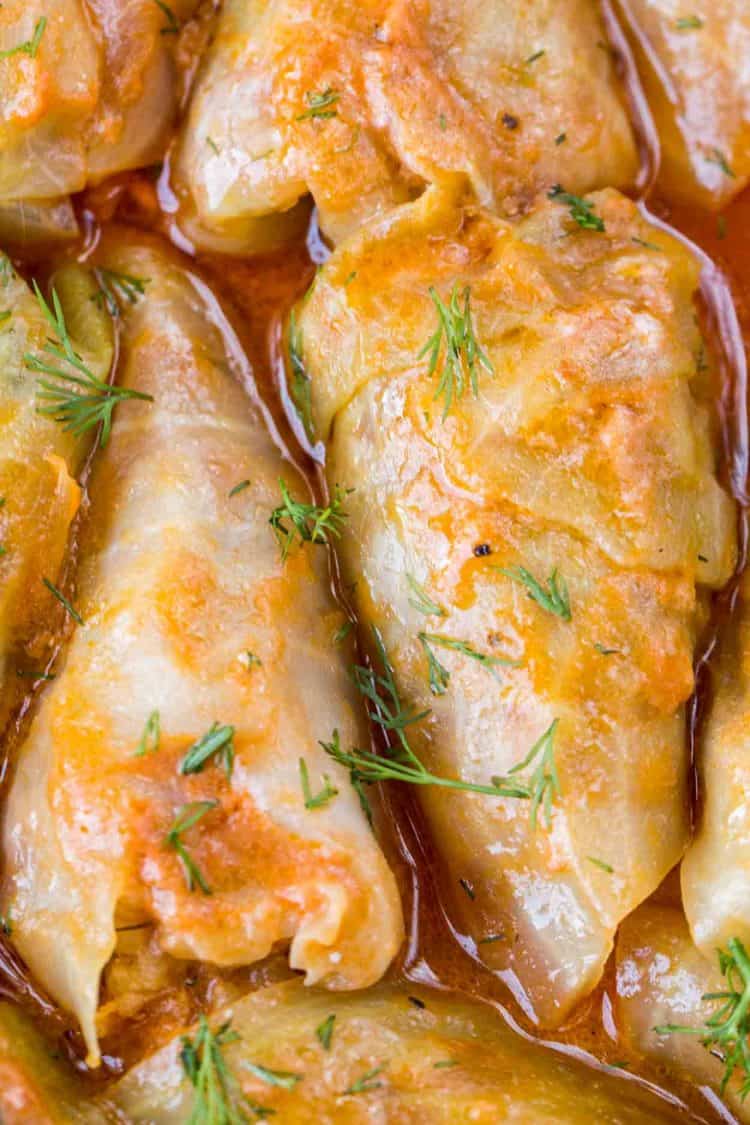 Up close picture of stuffed cabbage topped with ground pepper and fresh dill.
