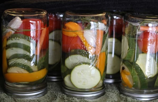 Canned zucchini in mason jars laid out upside down.