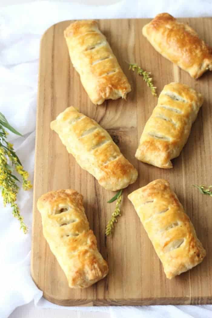 Crispy chicken potato pastry pies in a cutting board with flowers.