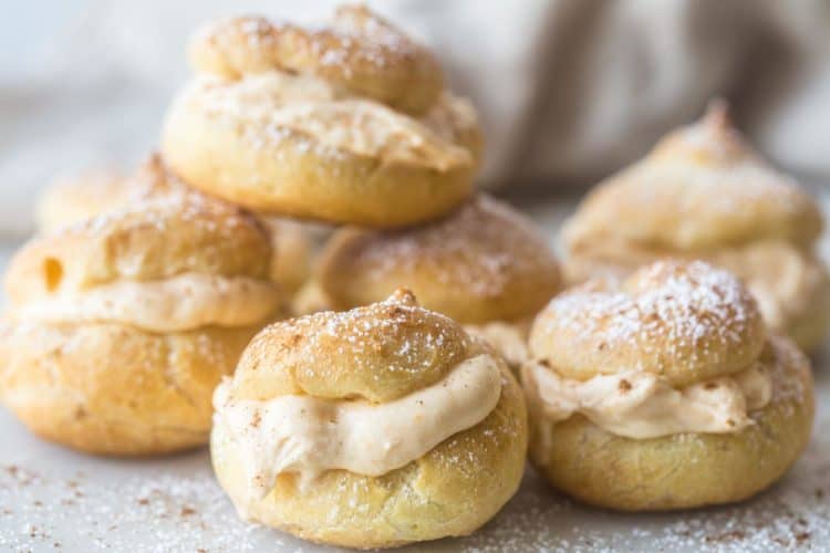 Fluffy cream puffs laid and filled with a pumpkin filling topped with powdered sugar. 