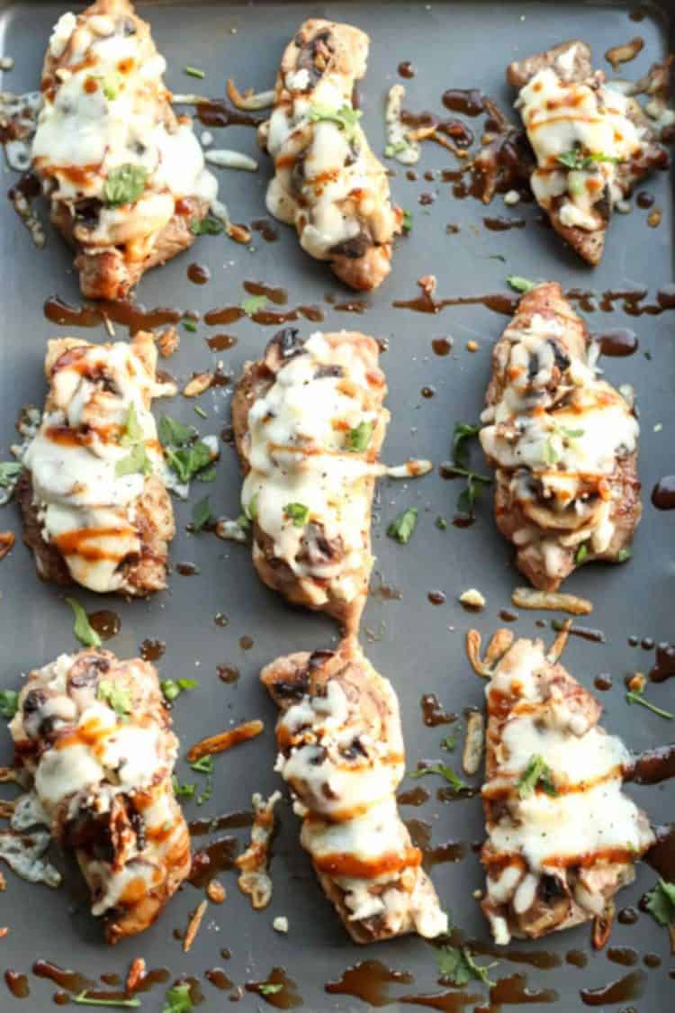 Pork chunks topped with feta and mushrooms, baked and topped with fresh greens and sauce.