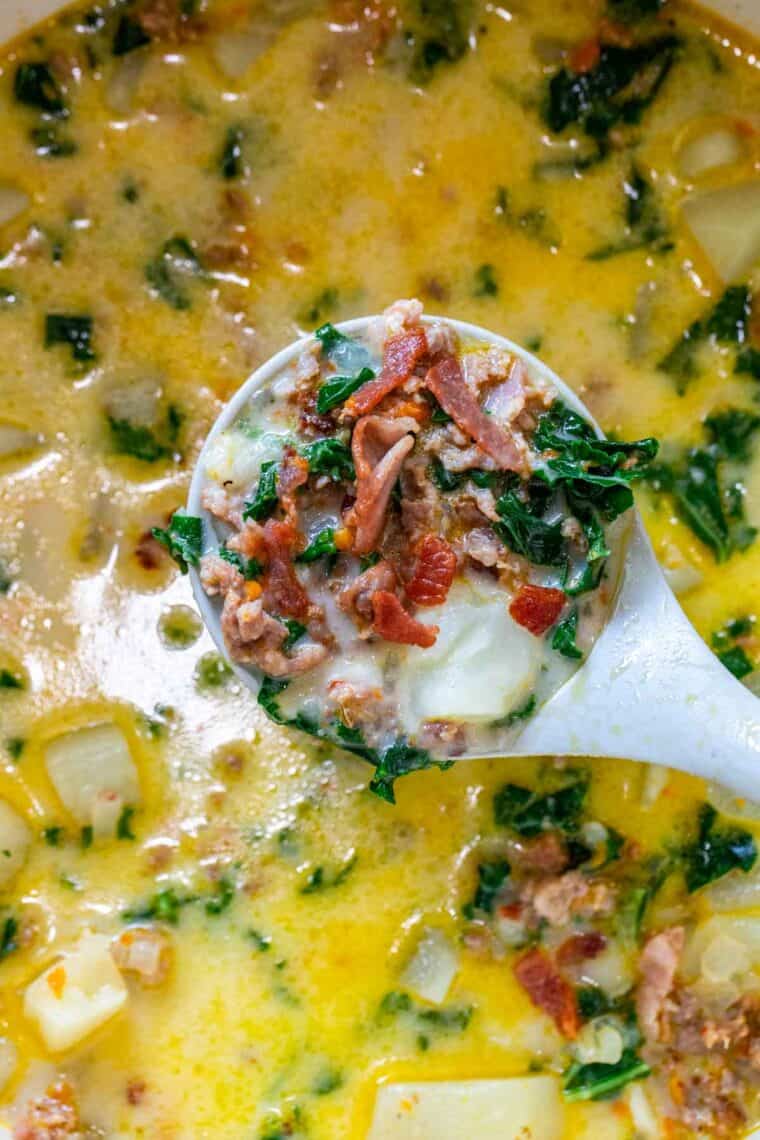 Zuppa Toscana in a Dutch oven with a ladle full of soup.