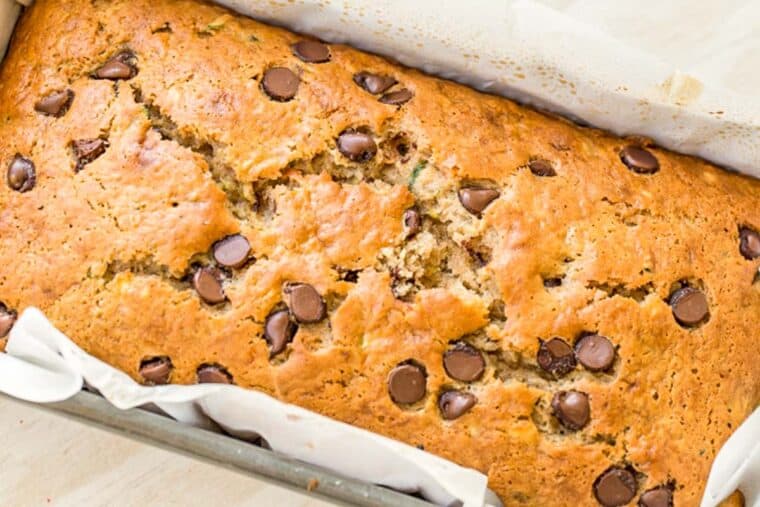 Zucchini banana bread loaf in a bread pan loaded with chocolate chips. 