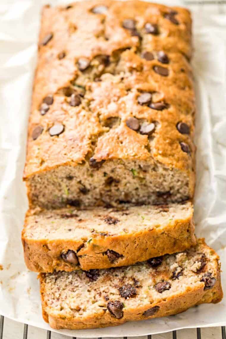 Zucchini banana bread recipe loaded with chocolate chips on parchment paper on a cooling rack. 