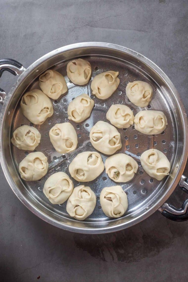 Formed manti dumplings in a steamer pot ready to be cooked.