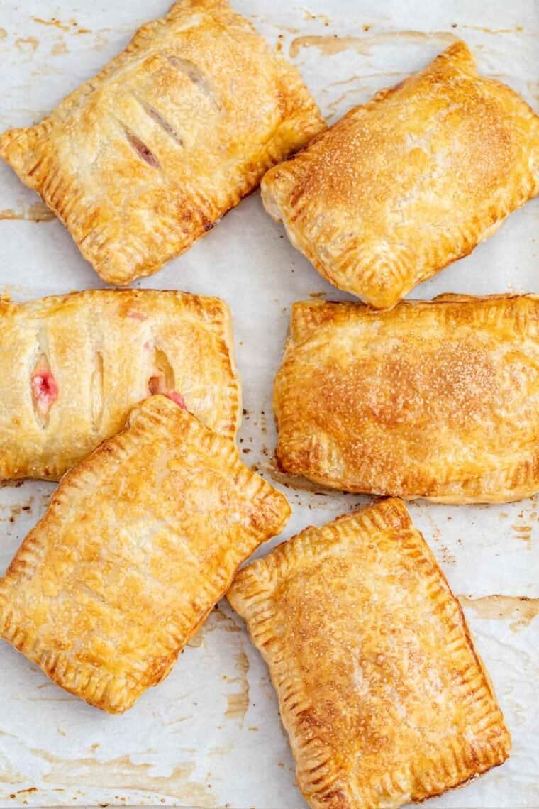 Puff pastry hand pies laid out in a baking sheet. 