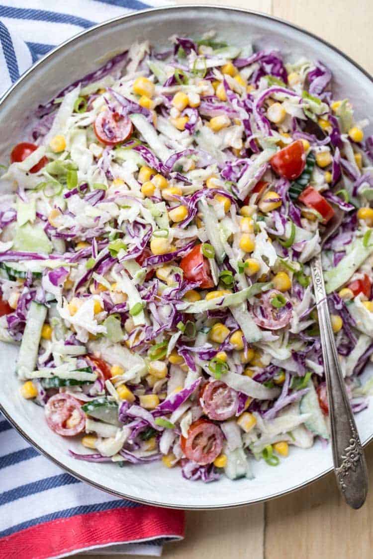 Corn tomato red cabbage salad made with cucumbers, tomatoes, and cabbage in a bowl.