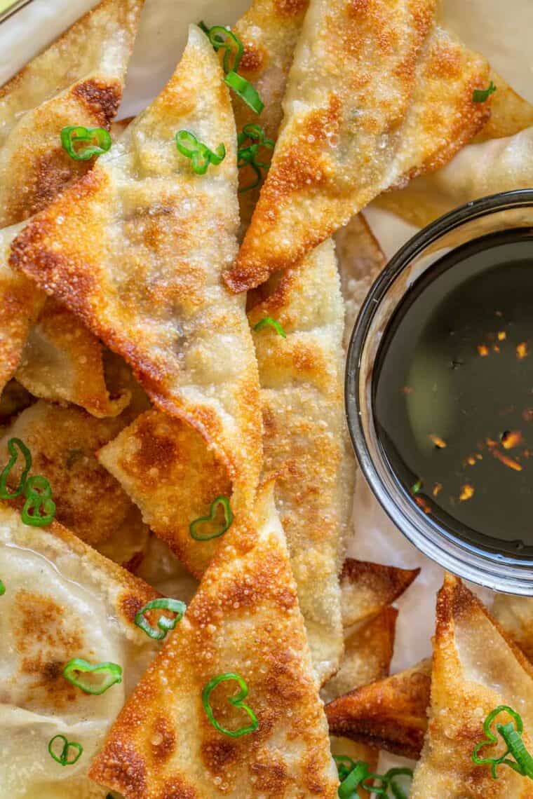 Crispy pork potstickers topped with green onions.  