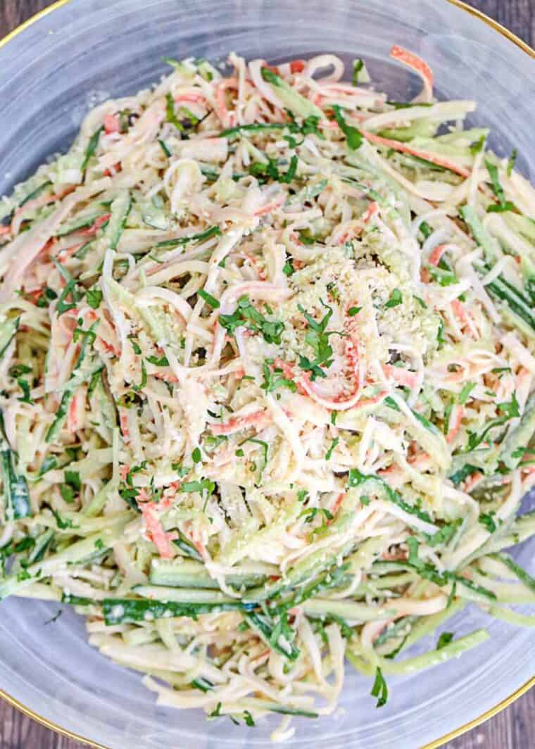 Crab Cucumber Kani Salad Recipe in a bowl with a spoon topped with crumbs.