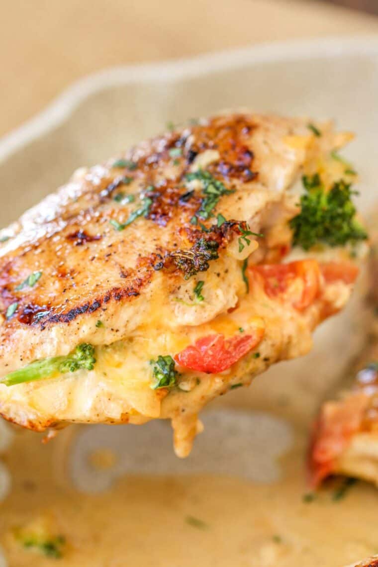 A stuffed chicken breast stuffed with cheese, tomatoes and shredded cheese topped with fresh chopped greens. 