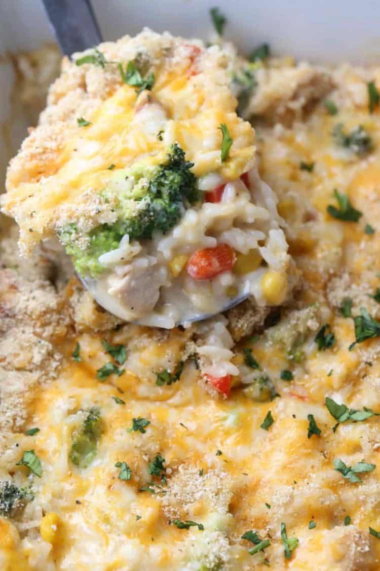 A large spoonful of Chicken Broccoli Rice Casserole in a baking dish.