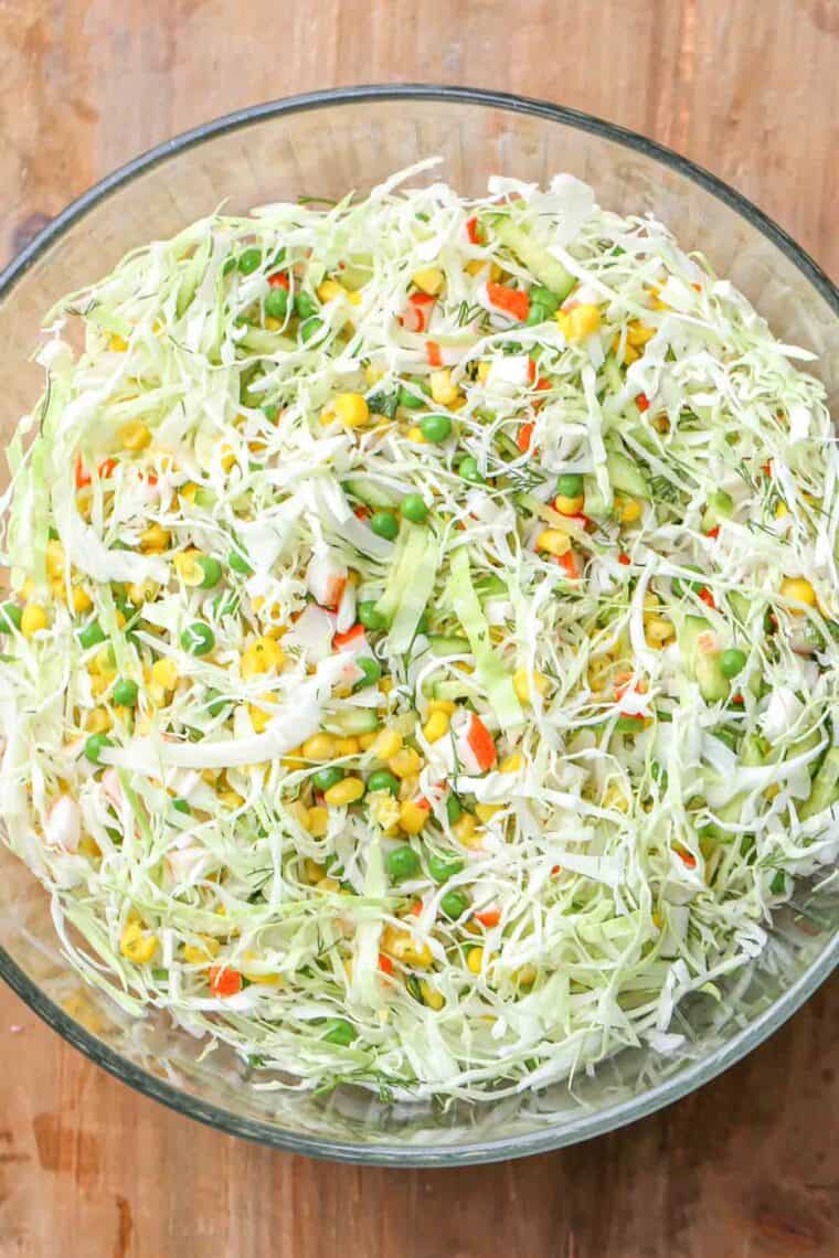 Unmixed creamy cabbage salad in a glass bowl. 