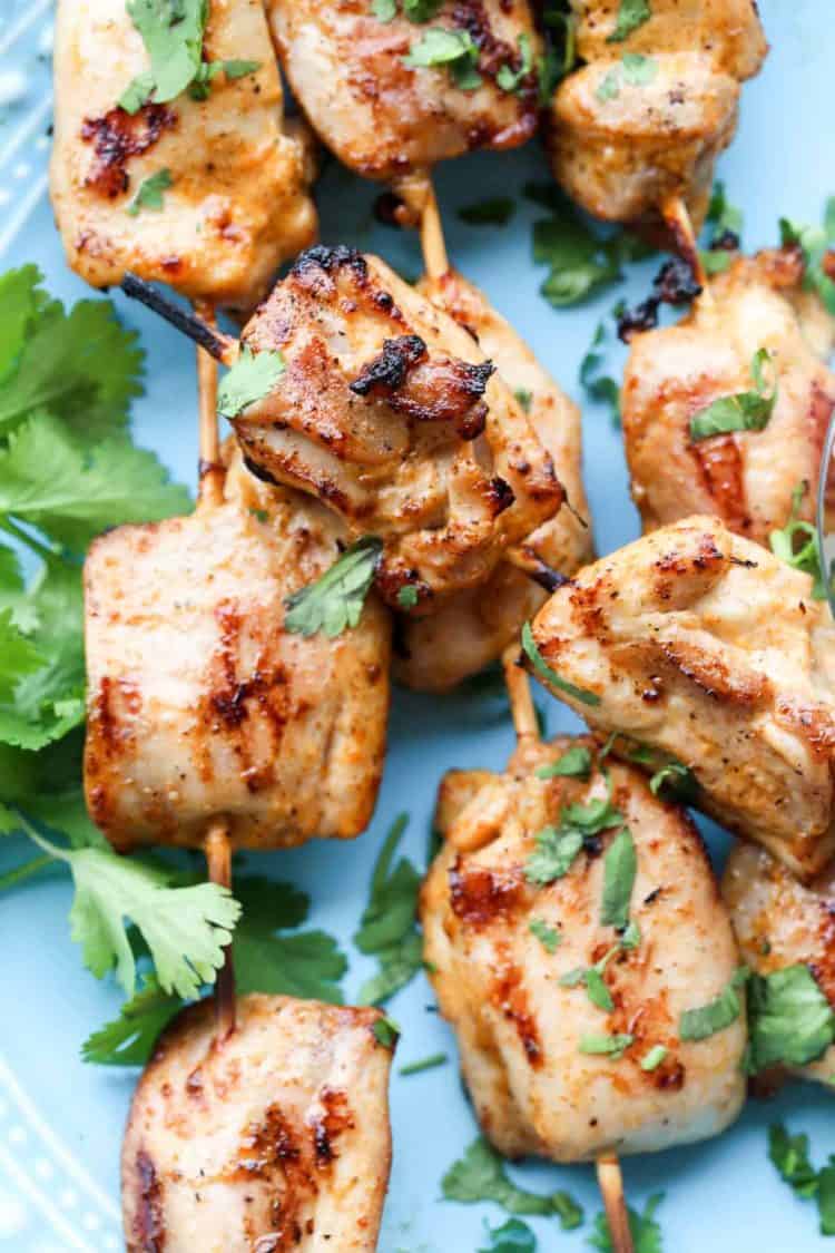 A close up of Grilled Buffalo Ranch Chicken on skewers, topped with fresh cilantro.