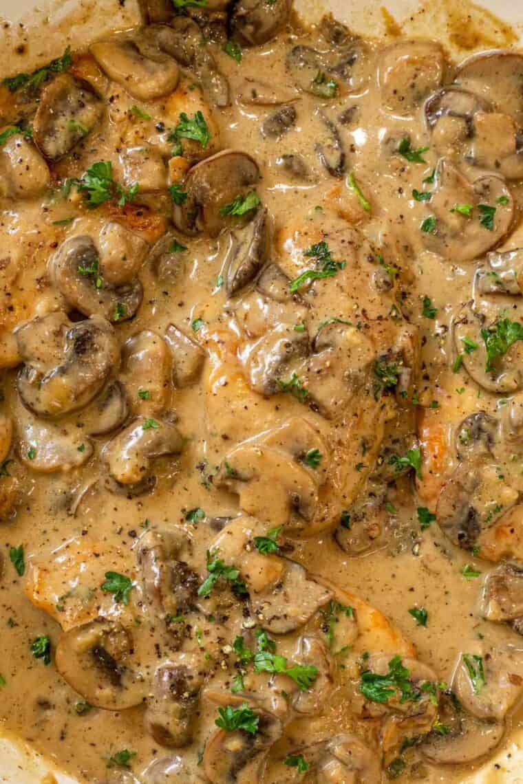 Upclose picture of chicken marsala topped with fresh chopped greens. 