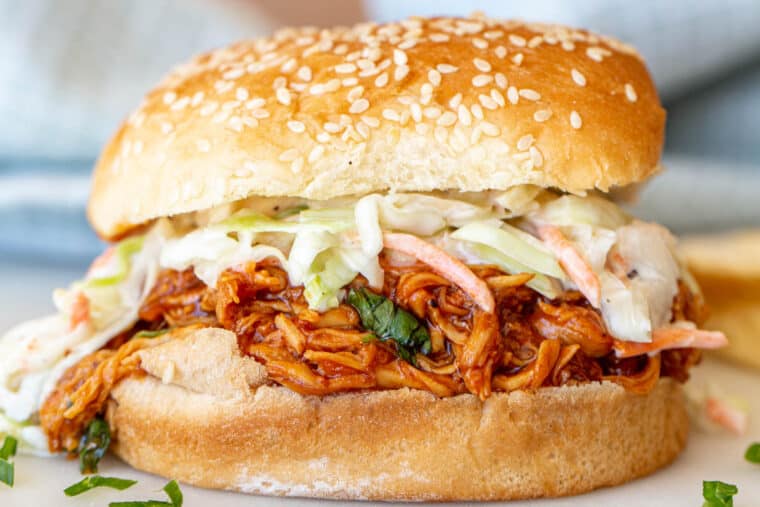 BBQ pulled chicken in a sandwich with coleslaw. 