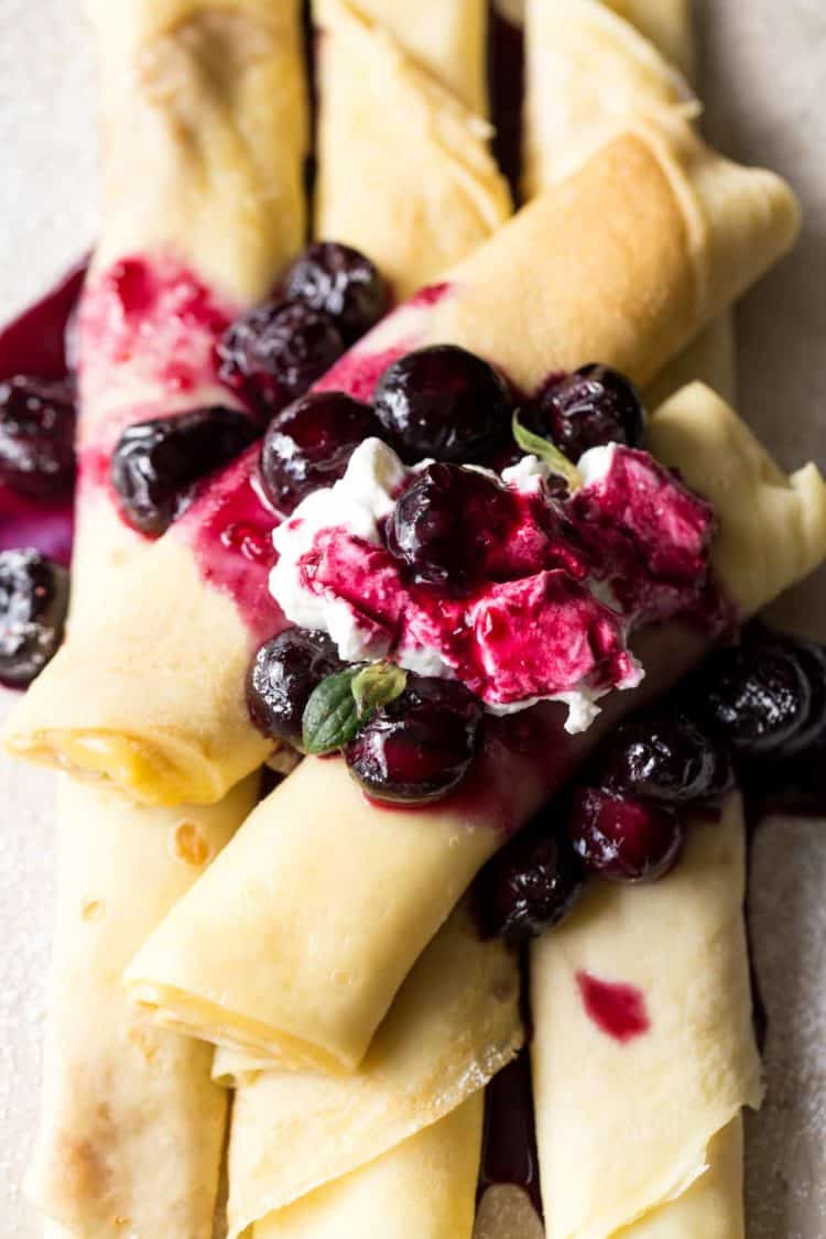 Custard filled crepes with a blueberry sauce filling and whipped cream.