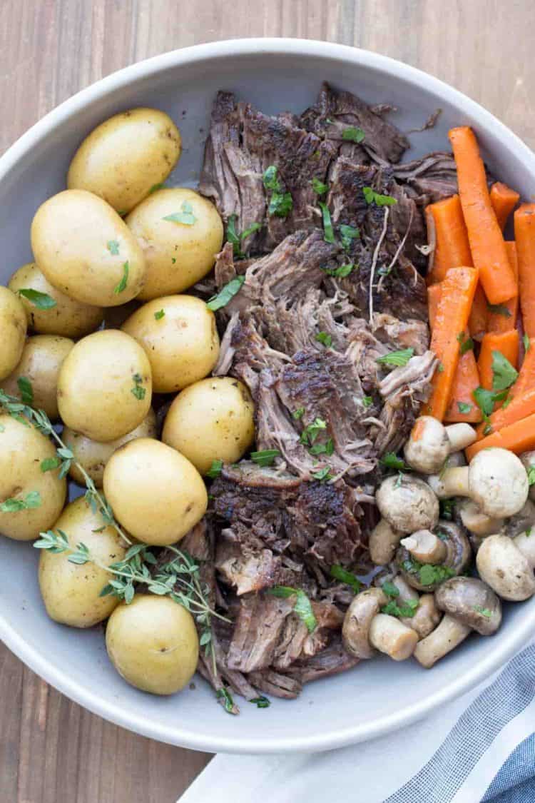 Roast beef recipe made with beef chuck, carrots, and potatoes in a plate.