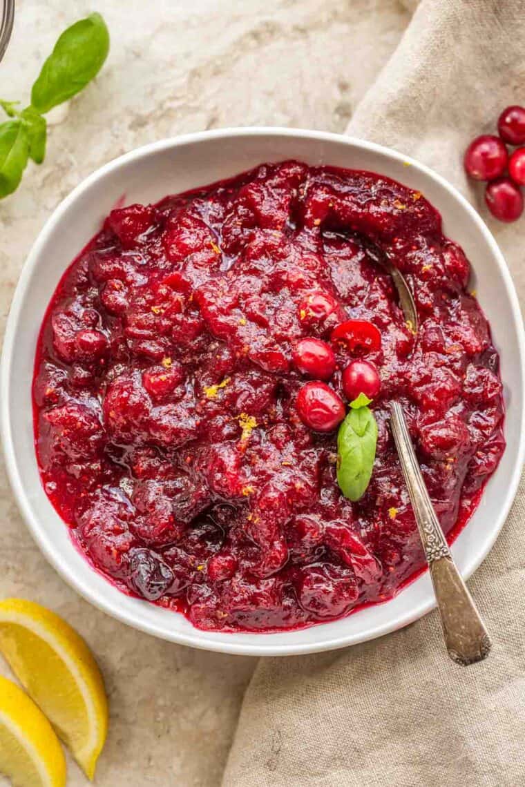Homemade cranberry orange sauce in a bowl topped with orange zest. 