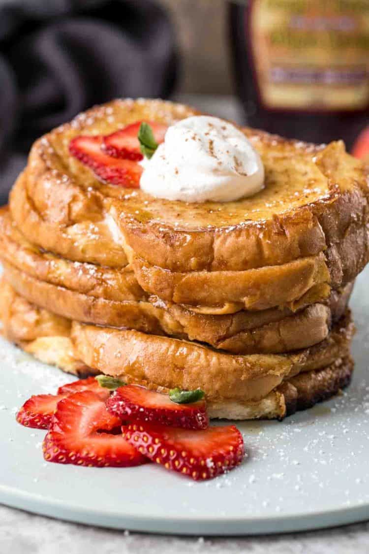 Strawberry cheesecake stuffed french toast recipe, topped with whipped cream and fresh strawberries.