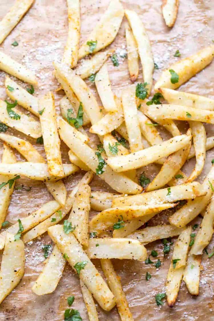 Baked French fries topped with pepper, parmesan cheese, and fresh cilantro.