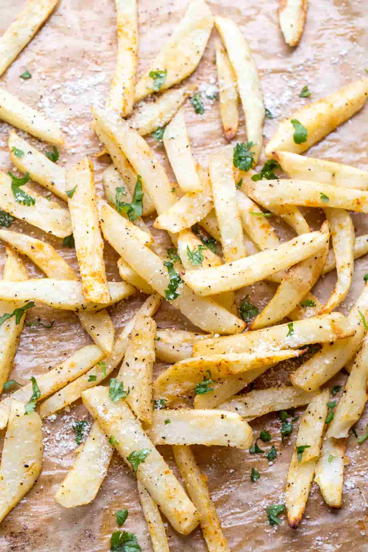 Baked French fries topped greens and parmesan cheese.