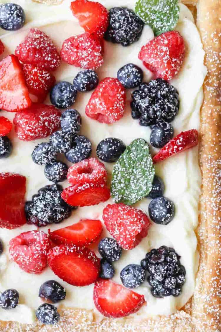 Puff pastry tart topped with berries, mint and powdered sugar.