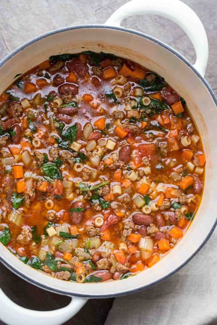 Pasta fagioli soup in a dutch oven with spinach, beans and pasta.