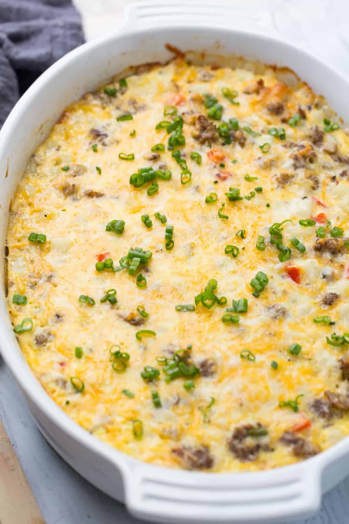 The best breakfast casserole with sausage and vegetables in a casserole dish.
