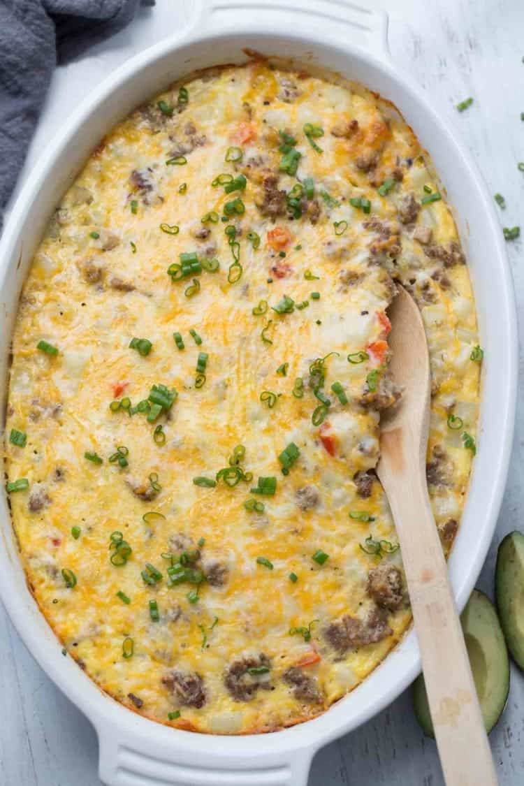 Sausage Breakfast Casserole Recipe in a baking dish with a wooden spoon.