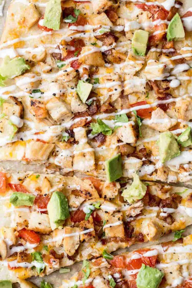 Close up of the flatbread pizza recipe topped with avocado and ranch drizzle. 
