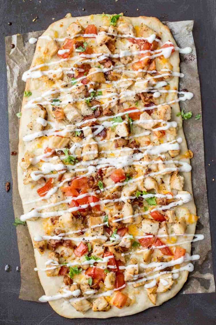 Avocado chicken flatbread recipe topped with tomatoes, bacon and cheese and drizzled with ranch! The best flatbread pizza recipe.
