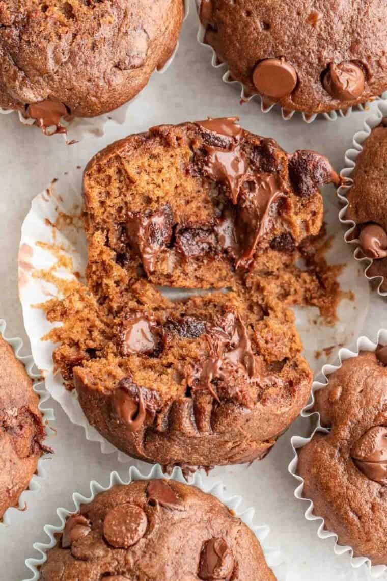 Chocolate muffins laid out with one being open.