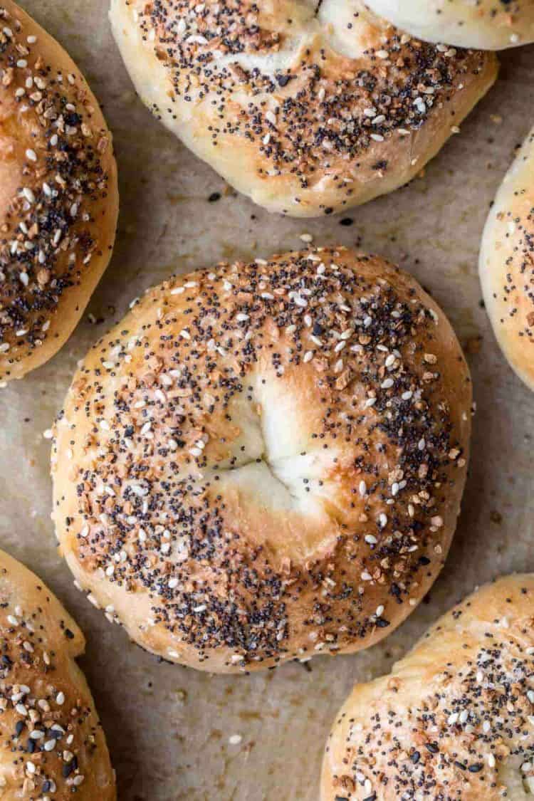 Everything bagel recipe topped with everything seasoning laid out on a baking sheet.