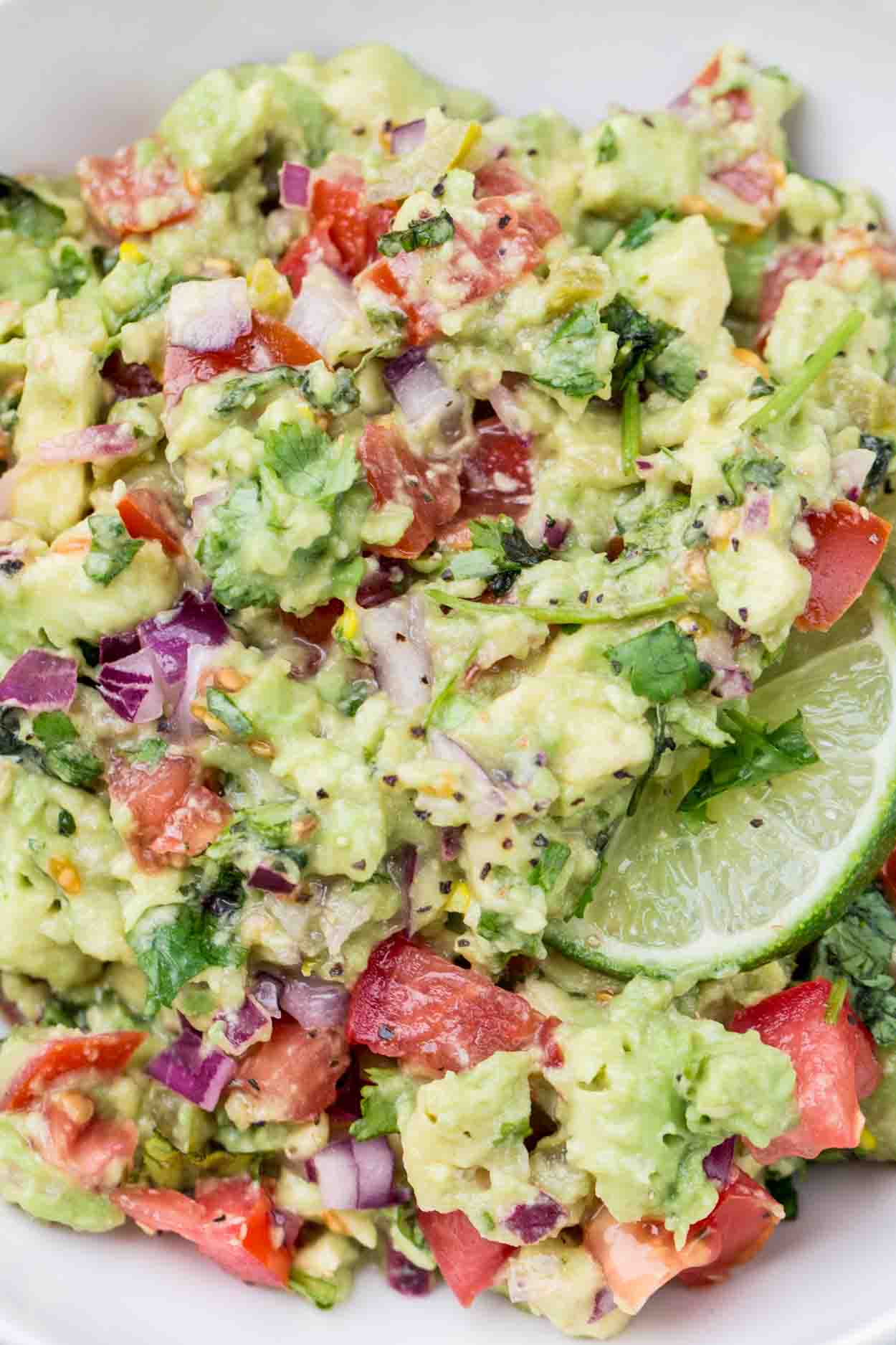 A recipe for the classic avocado dip. The best guacamole recipe made with cilantro and fresh tomatoes and lime juice. This dip is perfect for parties or potlucks and is so healthy.