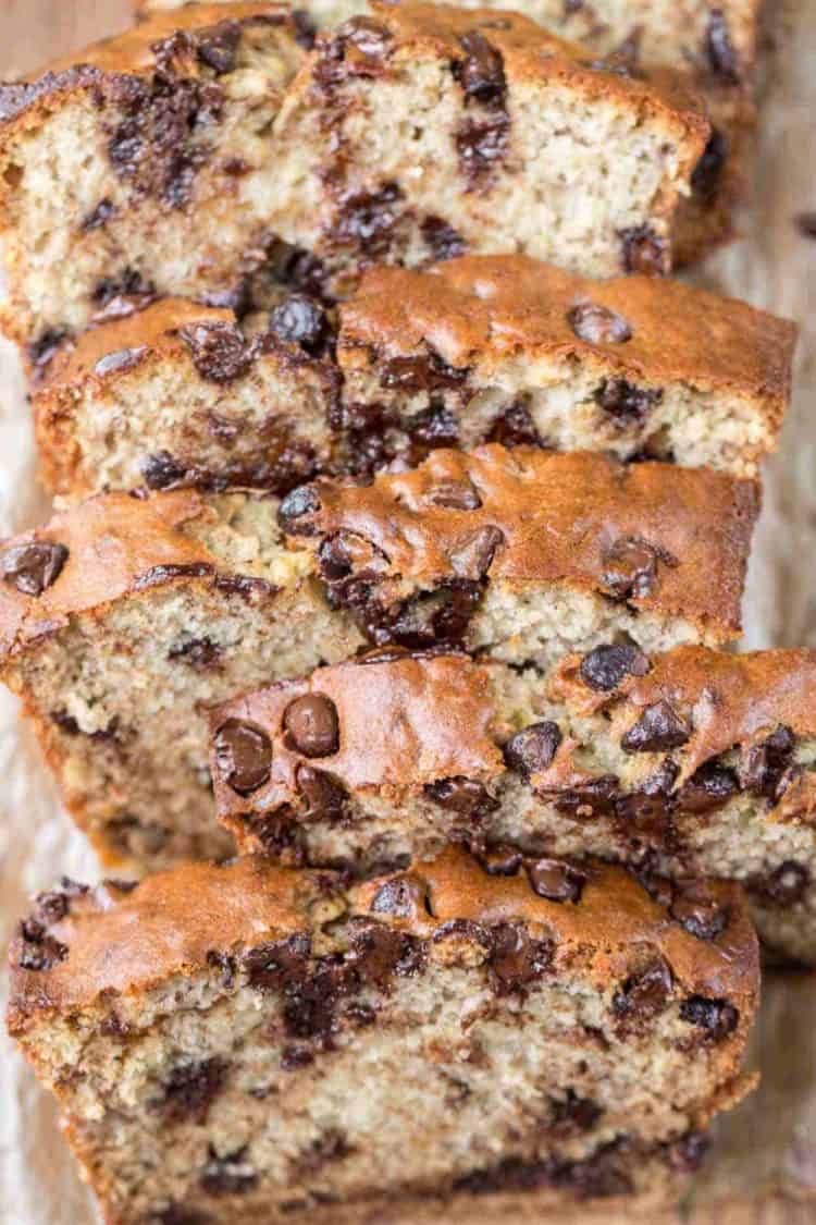 Banana bread sour cream cut into slices stacked with oozing chocolate chip morsels.