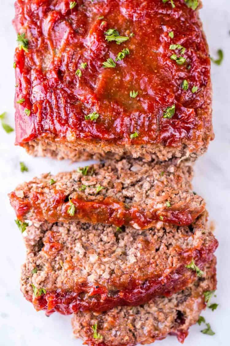 Meatloaf on a cutting board sliced into pieces.
