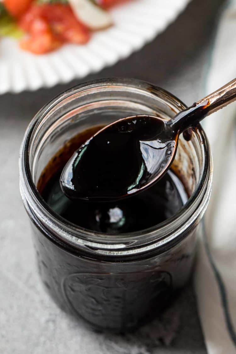 2-ingrient Balsamic Vinaigrette Recipe in a glass jar with a spoon.