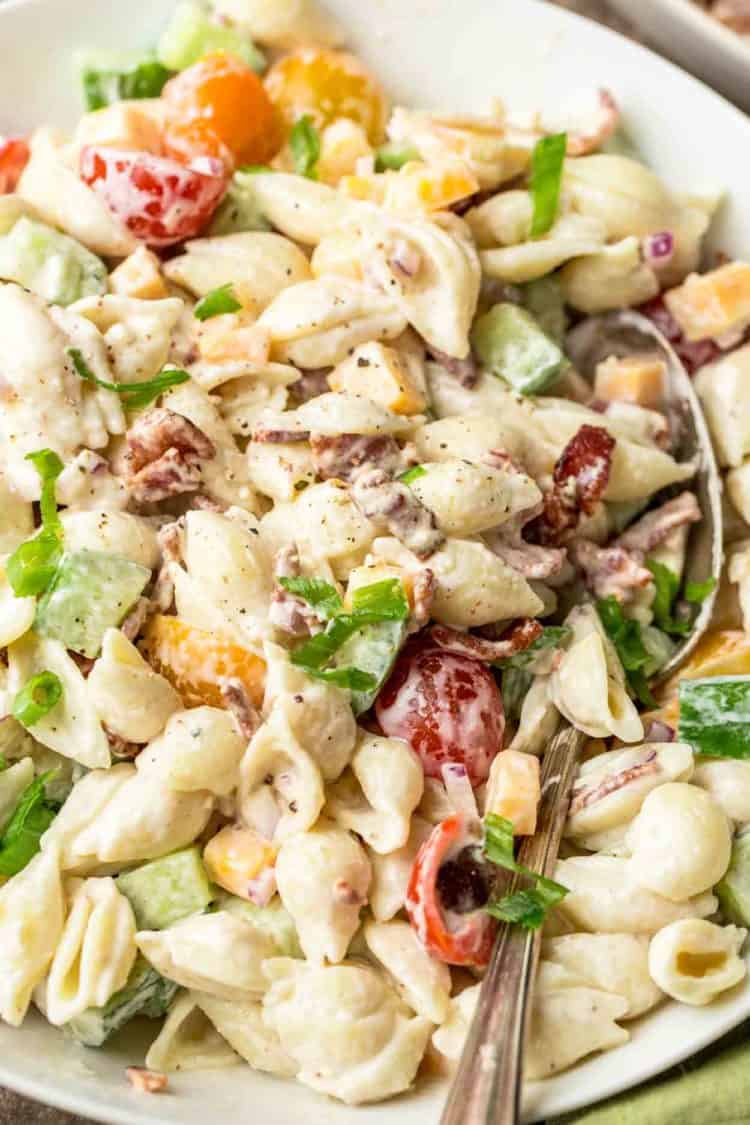 Easy pasta salad in a bowl tossed with homemade dressing and garnished with greens.