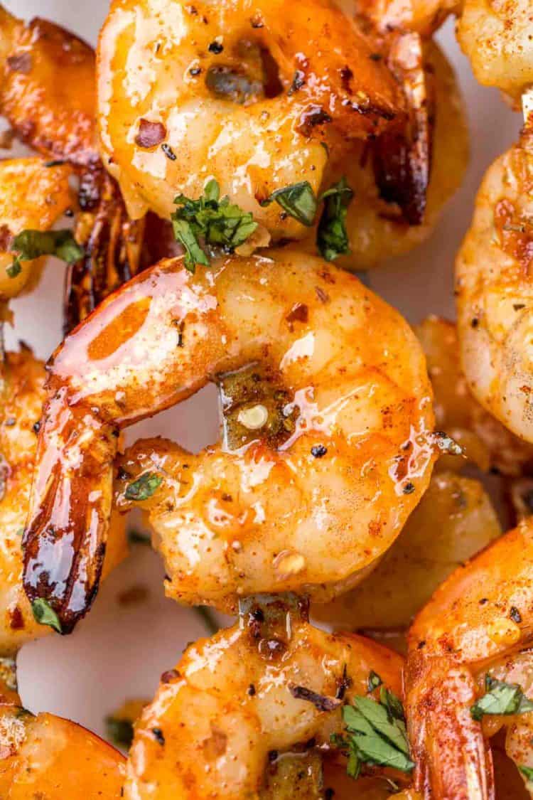 Marinated grilled shrimp recipe on skewers topped with fresh greens. 