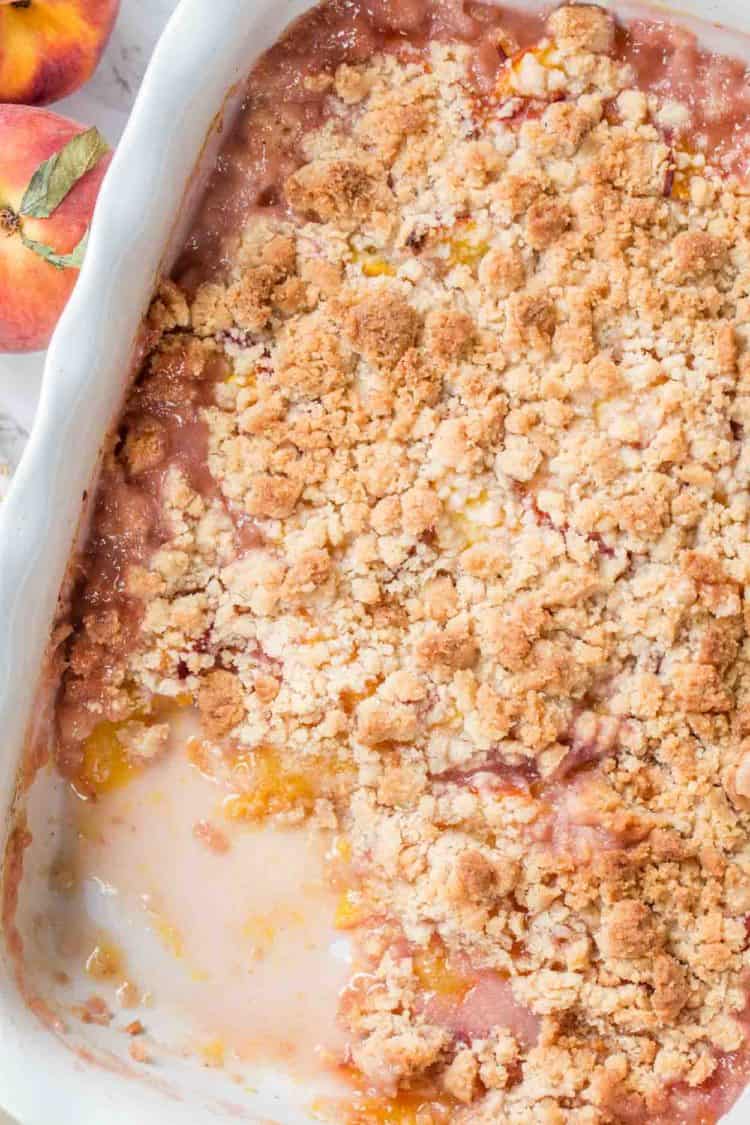Peach cobbler in a casserole dish topped with a simple crumble.