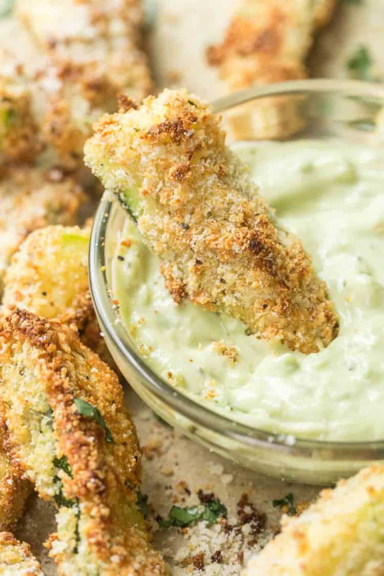 Baked zucchini in a bowl of avocado dipping sauce.