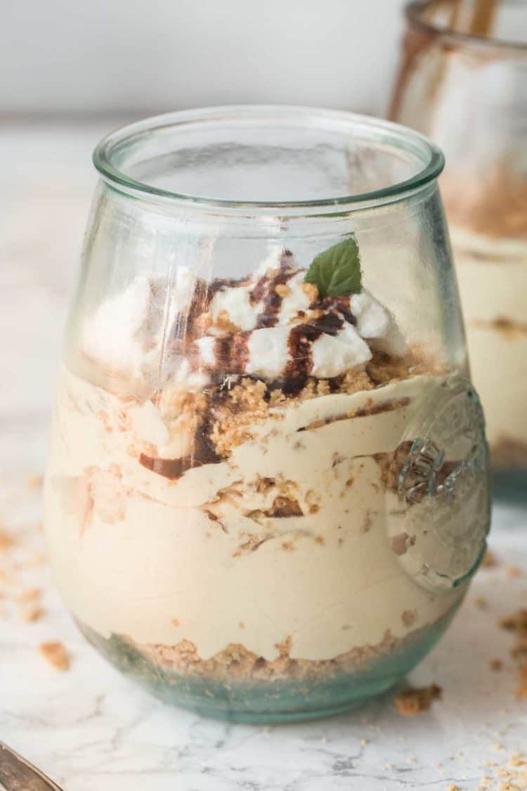 Peanut Butter Mousse Parfait in a glass cup topped with chocolate drizzle and crumbs.