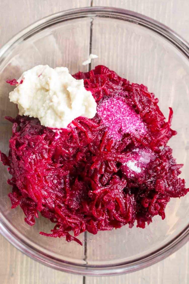 A white bowl with the ingredients for beet horseradish sauce. 