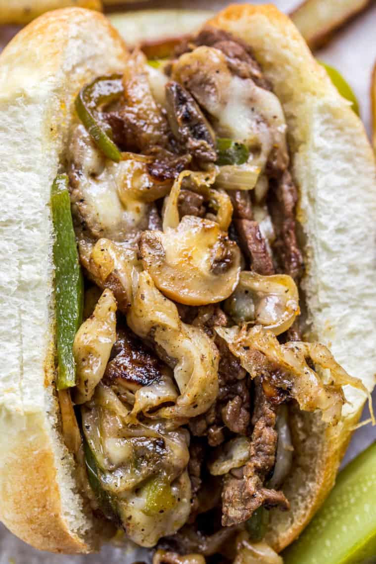 Philly cheesesteak sandwich loaded with mushrooms, peppers, onions and steak loaded with cheese. 